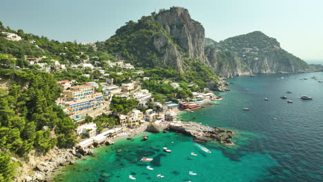 Drone-panning-shot-of-gorgeous-hotels-at-Capri-Spiaggia-di-Marina-Piccola-on-a-sunny-day