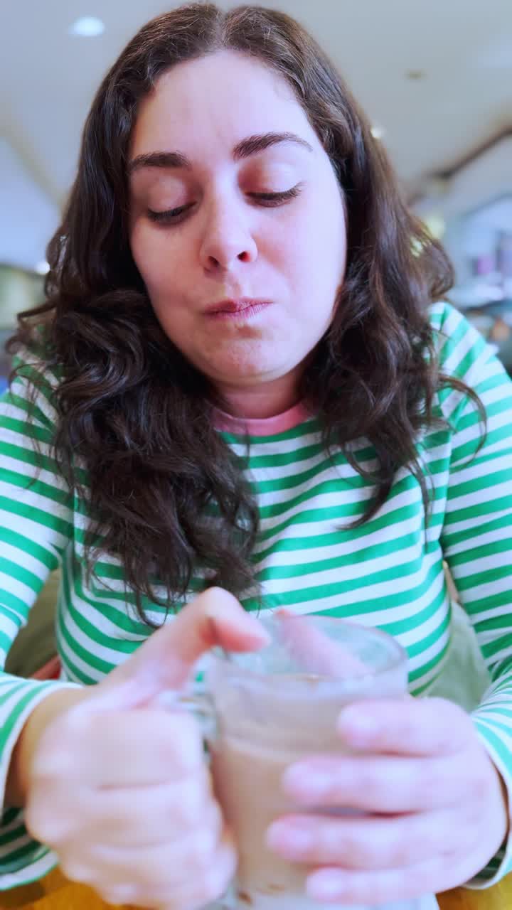 Young woman enjoying a hot beverage at a coffee shop