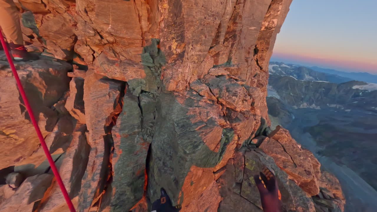 First-person POV of a climber ascending the iconic Matterhorn at sunrise on a crystal-clear bluebird day. Captured on GoPro for an immersive, realistic mountaineering experience above the clouds