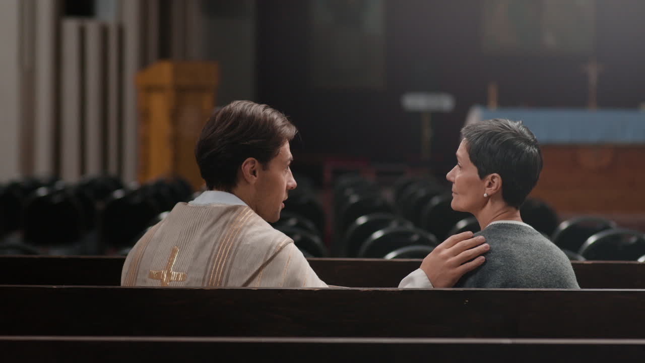 A priest and a woman sitting in a church