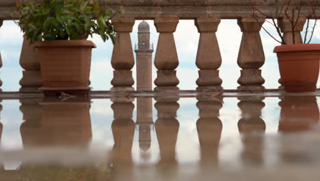 After-the-rain,-reflection-of-the-minaret-on-the-flat-balcony-of-another-historical-building-in-Mardin