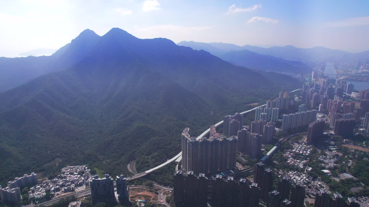 dos picos de alta montaña en el fondo con el ma ultramoderno en el distrito de shan de nuevos territorios en hong kong en un caluroso día de verano