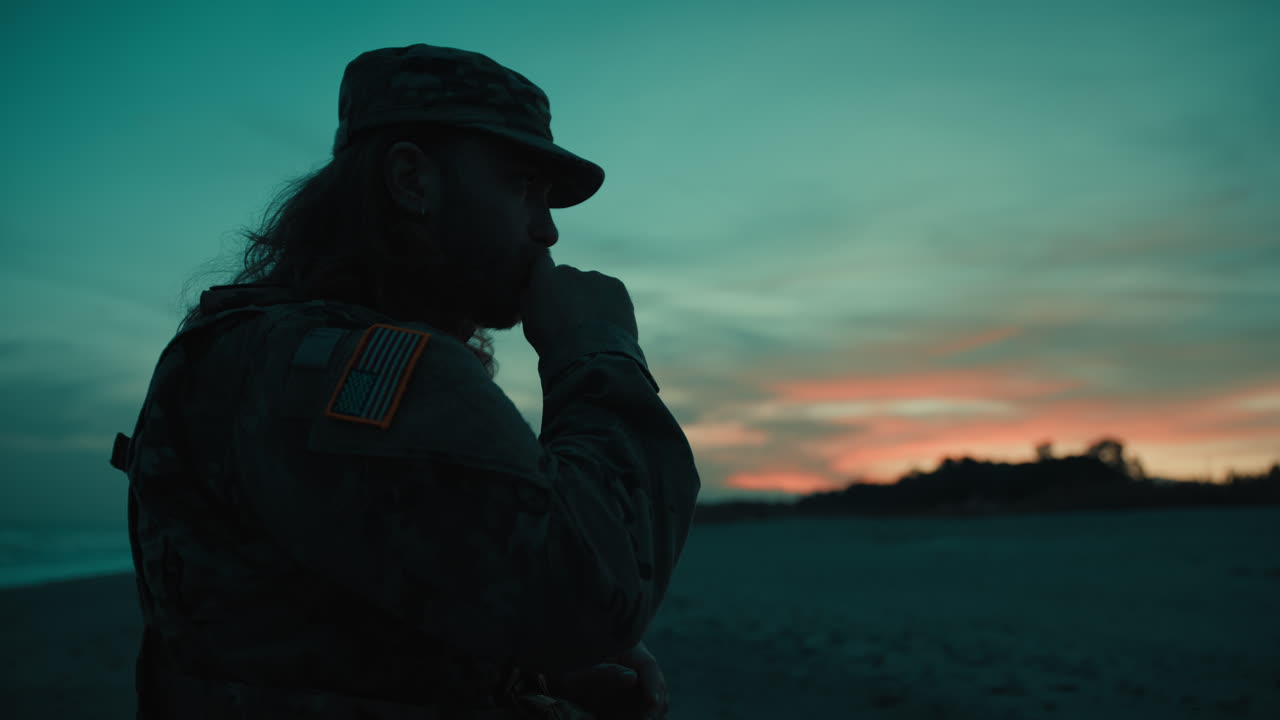 Silhouette of American soldier praying at sunset during Memorial Day Celebration
