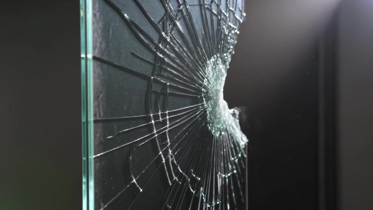 Recording tempered glass panel cracking from impact during studio test, radial shards ejecting
