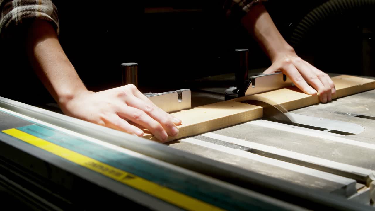 soldadora usando una sierra de mesa en una tabla de madera en el taller 4k