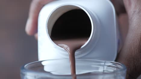 vertiendo leche de chocolate en un vaso