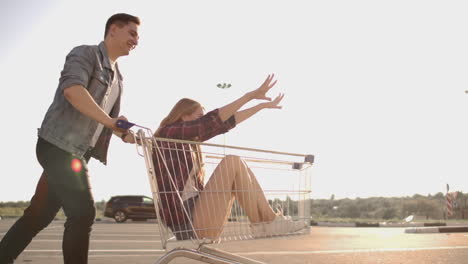amigos jóvenes divirtiéndose en carros de compras. jóvenes multiétnicos compitiendo en el carrito de compras. cámara lenta