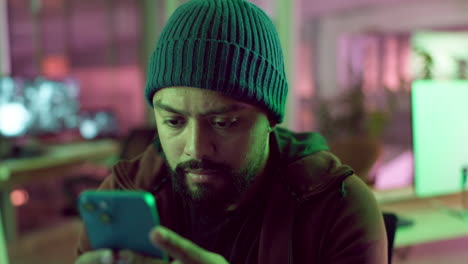 person looking at smartphone in a dimly lit office