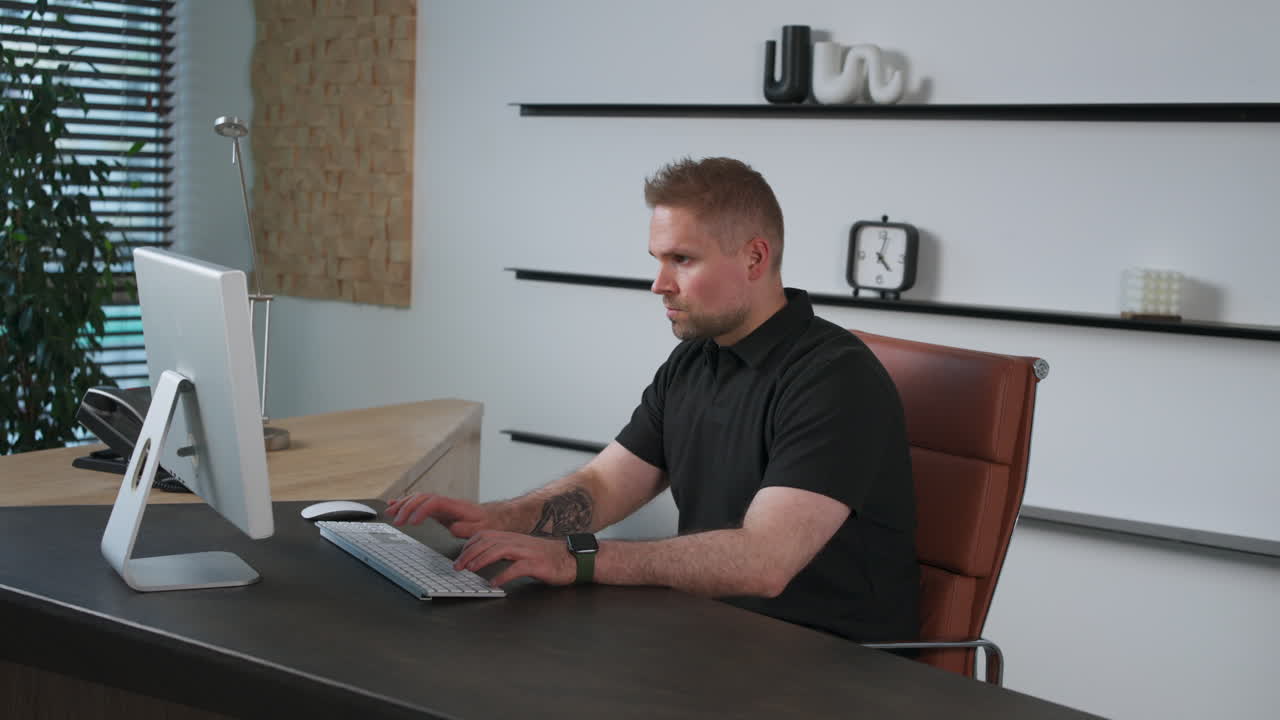 Corpulent spiky-haired man at work concentrating on the computer