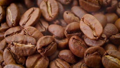 Close-up-of-seeds-of-coffee.-Fragrant-coffee-beans-are-roasted-smoke-comes-from-coffee-beans.