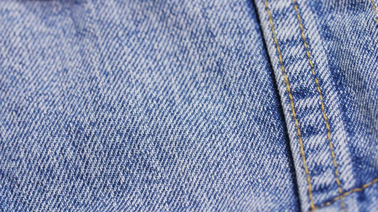 Panoramica macro su una giacca di jeans che mostra la fodera sherpa bianca e i dettagli delle cuciture