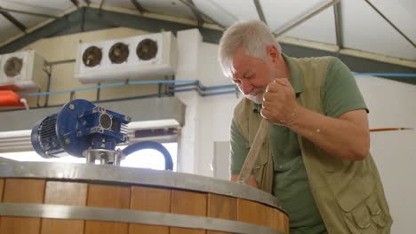 male worker stirring gin in distillery 4k