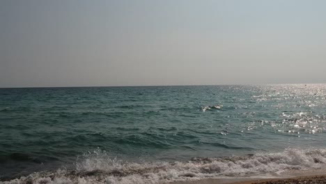 Disparo-Constante-De-Olas-Rompiendo-En-La-Playa-De-Arena-De-Una-Isla-Griega