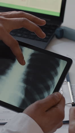 medical professionals analyzing x-ray on tablet