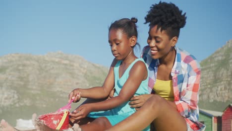 Glückliche-Afroamerikanische-Mutter,-Die-Mit-Ihrer-Tochter-Am-Sonnigen-Strand-Spielt