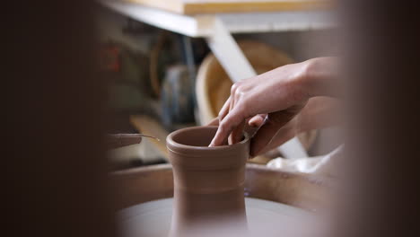 close up of young african american woman working at pottery wheel in ceramics studio