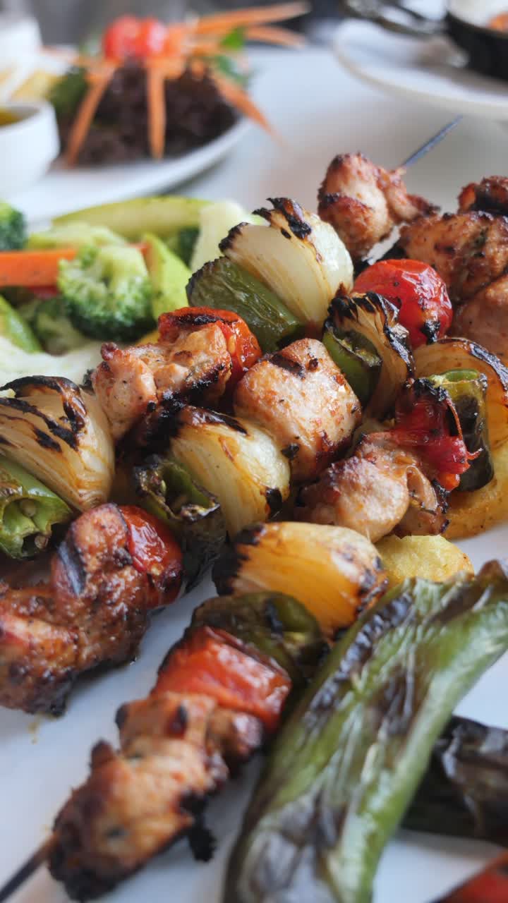 Spiedini di pollo e verdure alla griglia serviti con riso e patatine fritte