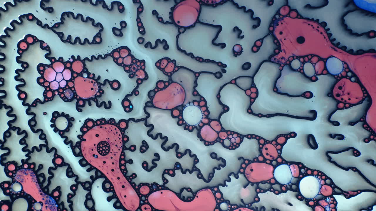 Abstract macro shot of colorful liquid patterns with black outlines and bubbles