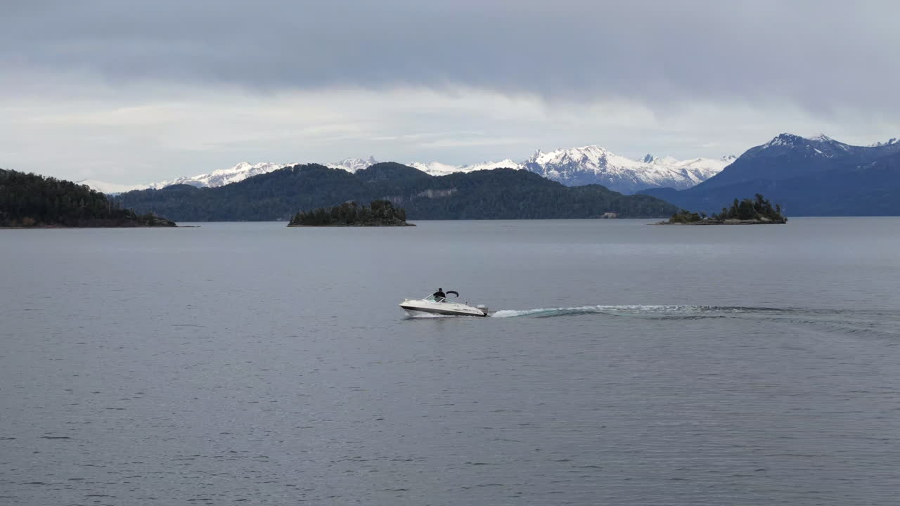 Speedboat navigating the waters of Lake Nahuel Huapi near Bariloche, Patagonia, Argentina, surrounded by stunning natural landscapes.