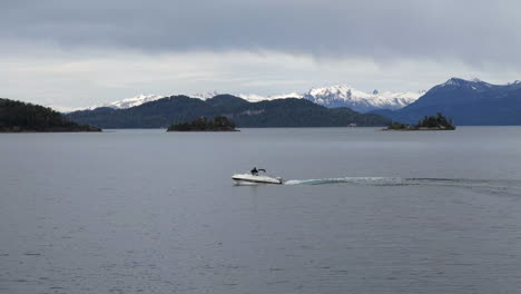 una lancha rápida navegando por las aguas del lago nahuel huapi cerca de bariloche, patagonia, argentina, rodeada de impresionantes paisajes naturales.