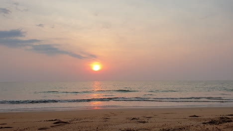 golden orange sunset over horizon in sandy beach of thailand