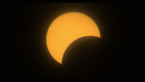 orange disc of the sun becoming eclipsed by moon