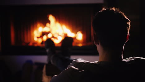 confident man resting at home by the fireplace