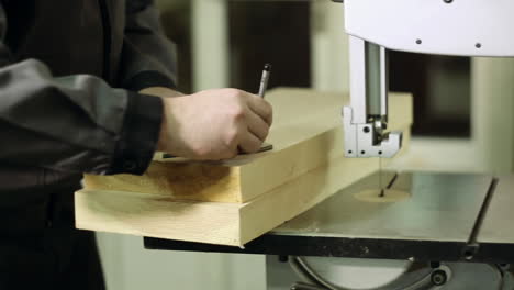 man cutting wood plank