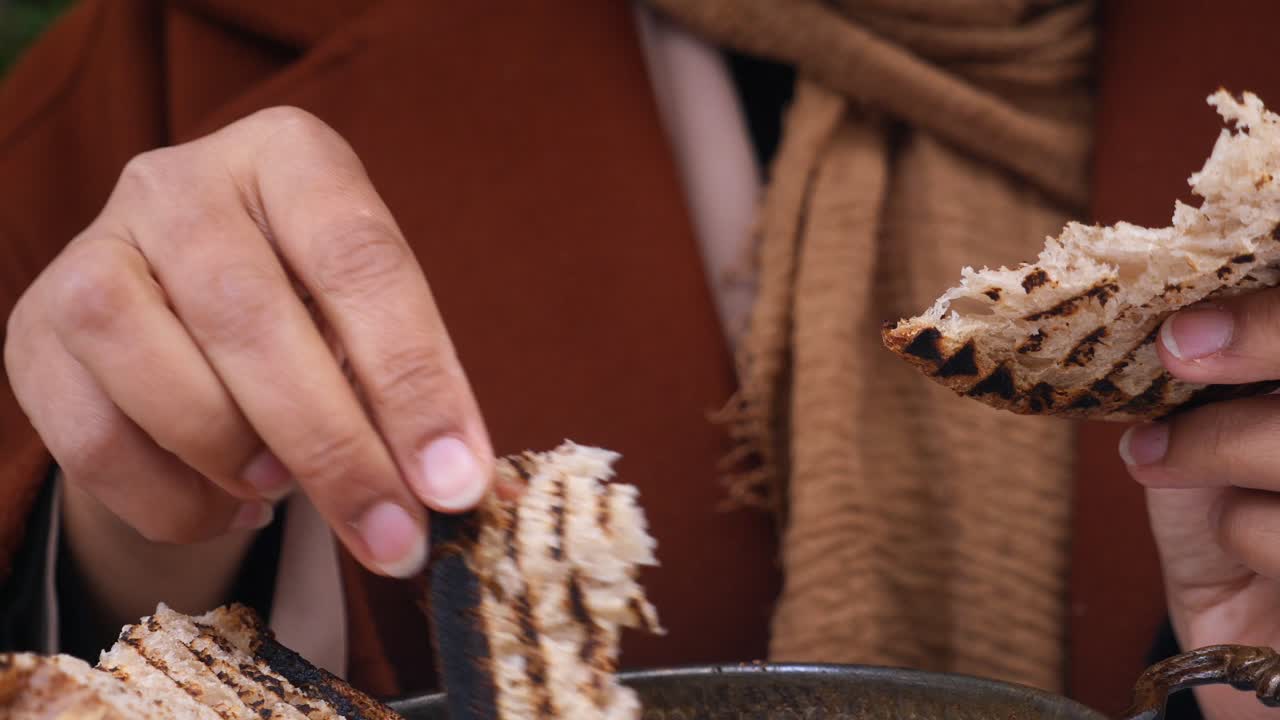 persona que come pan a la parrilla