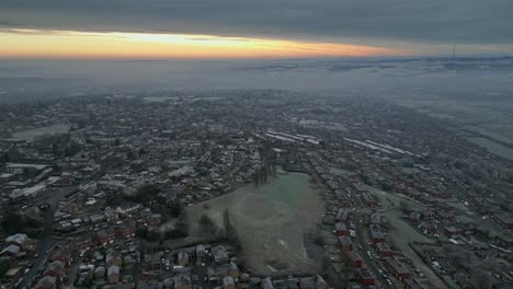 4k cinematic aerial footage, depicting a harsh english winter cold spell with mist, fog and freezing temperatures