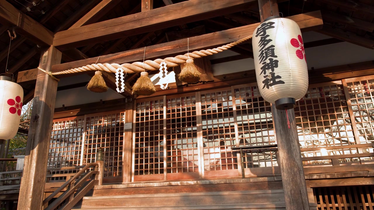 Plan moyen fixe d'un sanctuaire shinto en bois avec des lanternes en papier et une corde shimenawa