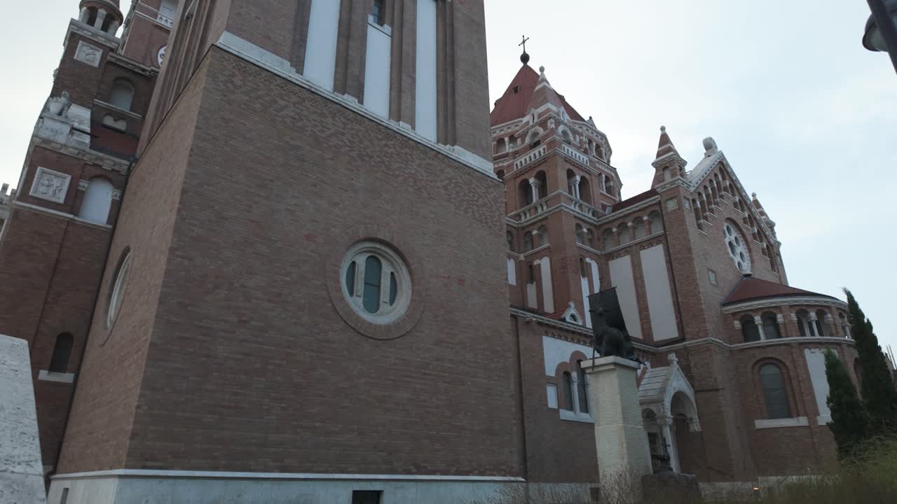 Tilt-down footage capturing the Votive Church in Szeged, Hungary, showcasing its iconic design and historic charm