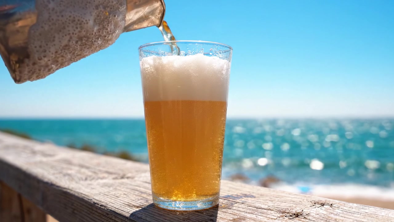 Una rinfrescante giornata estiva in spiaggia con una pinta di birra fredda: la combinazione perfetta di sole, onde e amici che si godono un momento di relax insieme