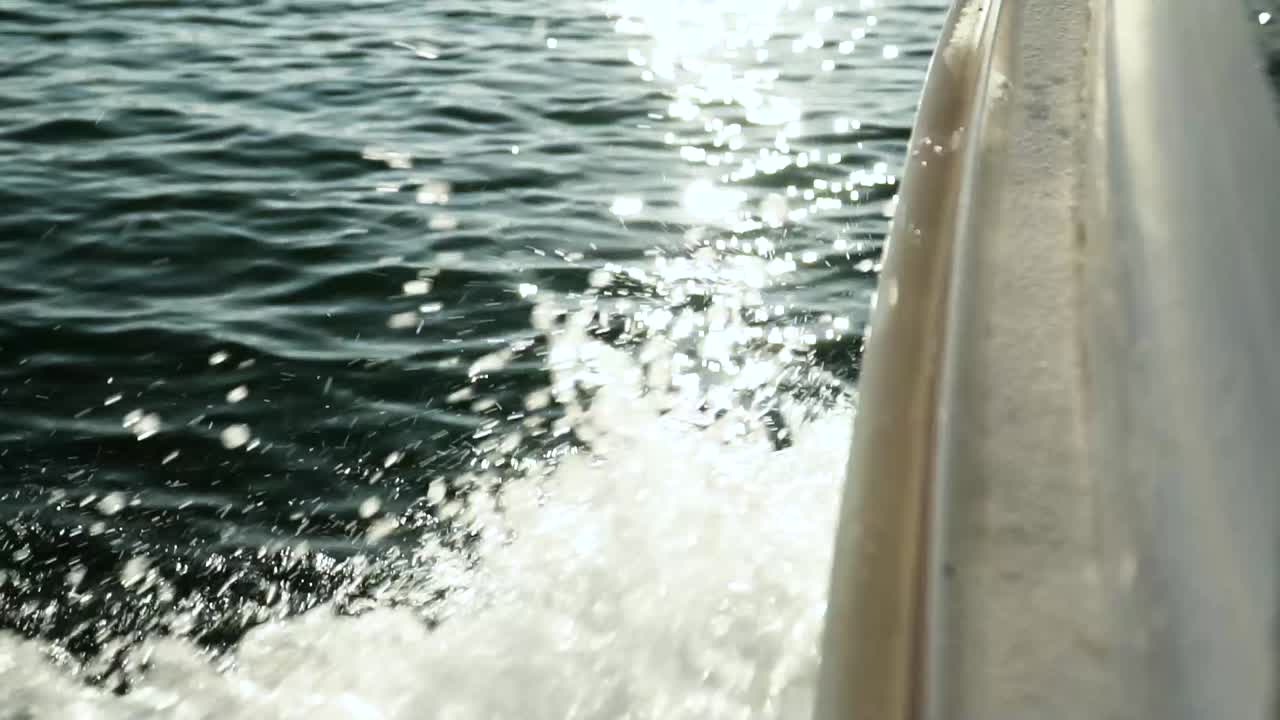 Primo piano estremo della prua di una barca che naviga sulle schizzi d'acqua marina in una giornata di sole
