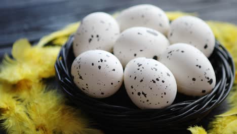 Ganze-Hühnereier-In-Einem-Nest-Auf-Einem-Schwarzen-Rustikalen-Hölzernen-Hintergrund-Ostern-Symbole