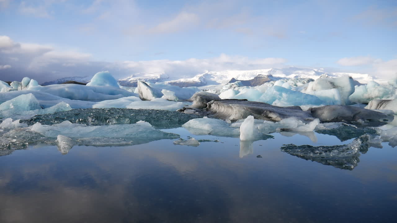 Elokuvamainen korkeuskuva pienistä jäävuorista Jökulsárlónin kansallispuistossa Islannissa