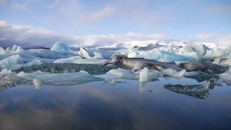 Filmische-Höhenaufnahme-Von-Kleinen-Eisbergen,-Die-Im-Jökulsárlón-Nationalpark-In-Island-Gefunden-Wurden