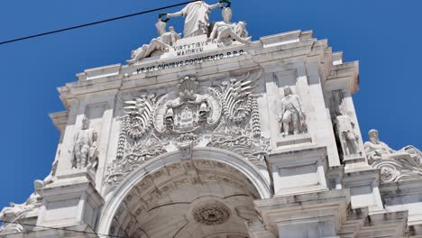 majestic rua augusta arch standing tall in commerce square, lisbon, portugal, under a vibrant blue sky. tilt up shot