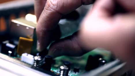 the engineer installing capacitor on motherboard