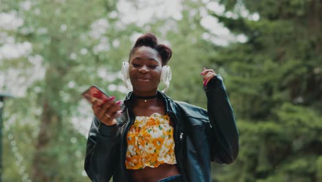 woman listening to music and dancing in a park
