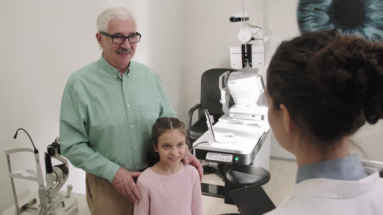 Senior Man And Little Girl In Ophthalmology Clinic