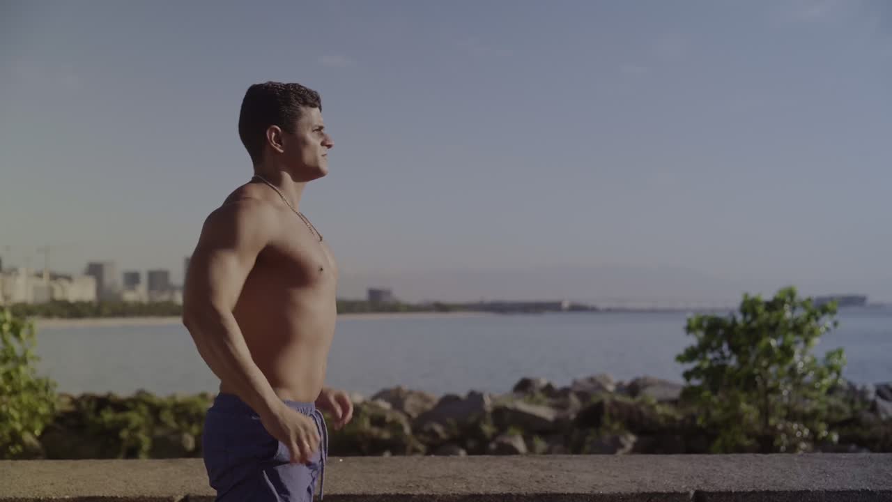 Man performing push-ups by the ocean