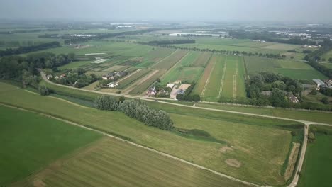 Toma-Aérea-De-Drones-De-La-Carretera-Junto-A-Los-Campos-Agrícolas-En-4k