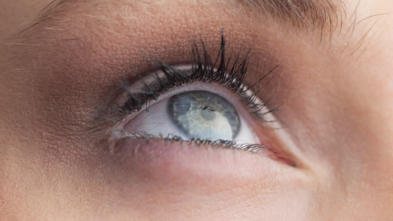 Close up of female grey eye against grey background