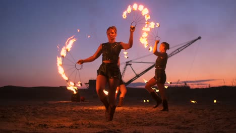 fire show. a group of professional artists performs a variety of fire facilities. boys and girls performed dances with fire in the night on the street in the park.