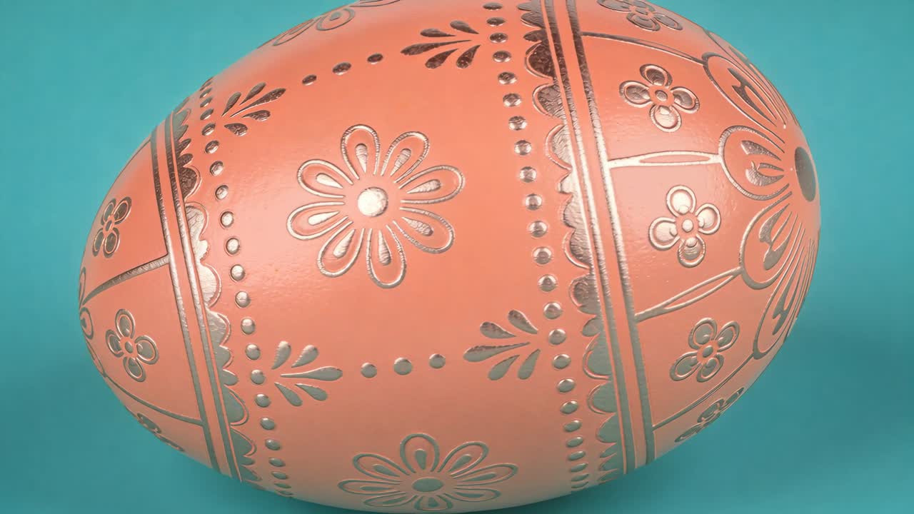 Playback starting, rotating decorated egg revealing coral base with gold floral bands on teal stand