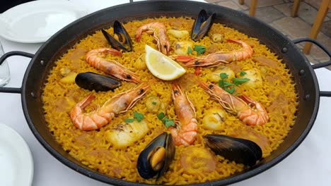 a vibrant seafood paella with shrimp and mussels garnished with lemon and fresh parsley, perfectly cooked and visually appealing for an inviting dining experience