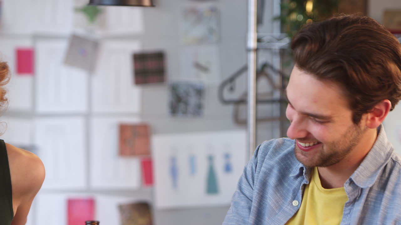 los diseñadores de moda masculinos y femeninos se reúnen y charlan en el estudio de diseño juntos