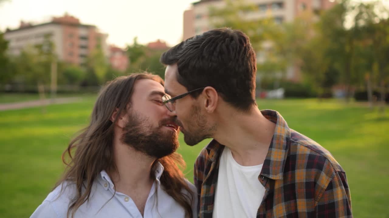 Coppia gay si scambia un bacio romantico in un parco