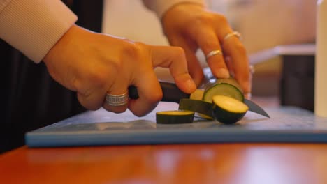 woman-cutting-cucumber-slices-in-a-kitchen